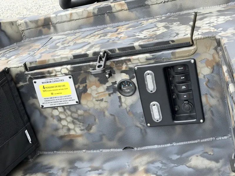 Slide: The Image of Close-up of a boat dashboard with camouflage pattern, switches, and a capacity label. - 6