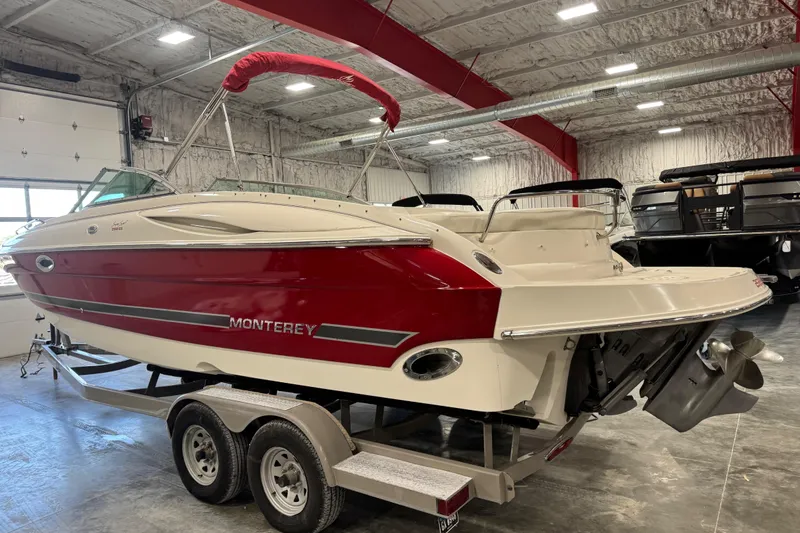 Slide: The Image of 2005 Monterey 268SS Super Sport boat in a warehouse, red and white exterior, on a trailer. - 4