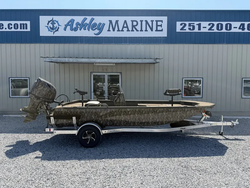 The Image of A Thor LAKE HAMMER 1900 CC boat on a trailer in front of a marine shop. - 1
