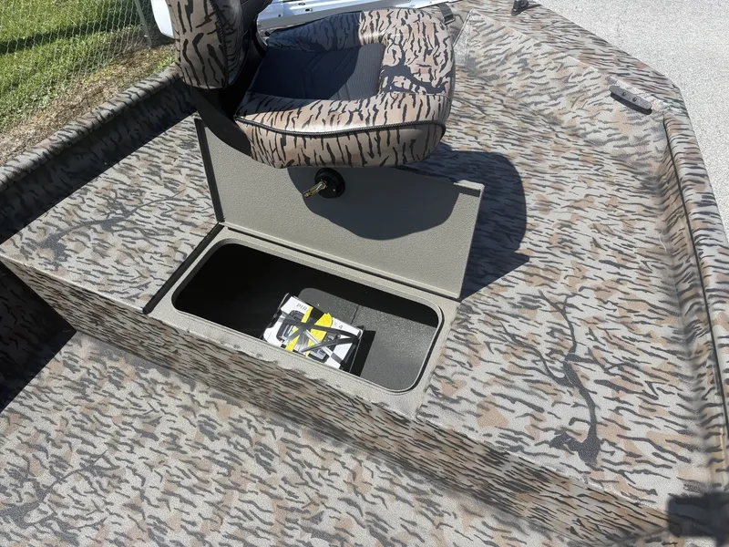 Slide: The Image of A 2027 Xpress XP20CC boat with an open storage compartment and a seat on a patterned deck. - 4