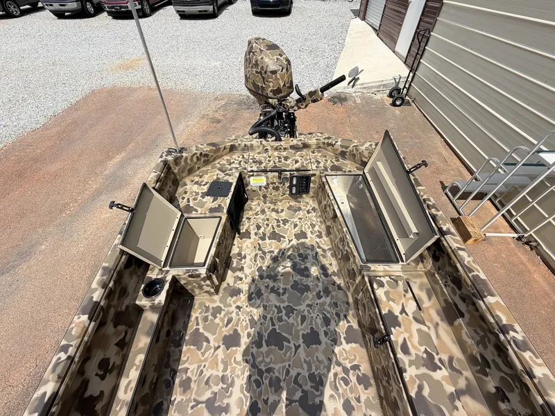 Slide: The Image of The image shows a camouflaged aluminum boat with open storage compartments and an outboard motor. - 7