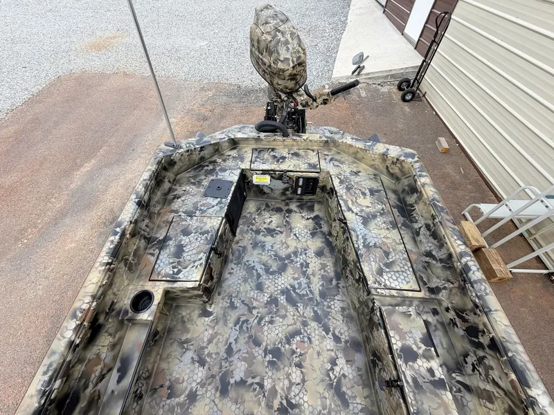 Slide: The Image of The image shows a camouflaged aluminum boat with an outboard motor, sitting on a trailer. - 7