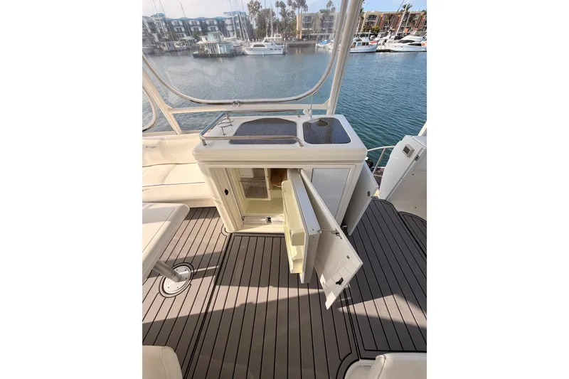 Slide: The Image of 2005 Cruisers Yachts 405 Express Motoryacht interior with open cabinet and marina view. - 29