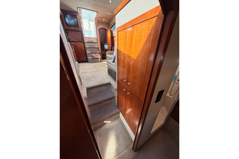 Slide: The Image of Interior view of 2005 Cruisers Yachts 405 Express Motoryacht with wooden cabinetry and carpeted stairs. - 65