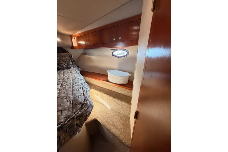 Slide: The Image of 2005 Cruisers Yachts 405 Express Motoryacht cabin interior with bed and wooden cabinetry. - 61