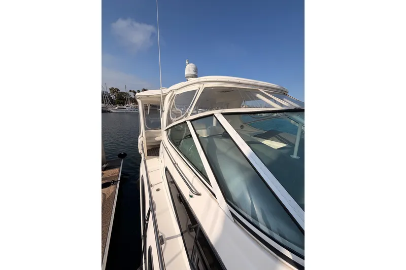 Slide: The Image of 2005 Cruisers Yachts 405 Express Motoryacht docked at marina under clear blue sky. - 23