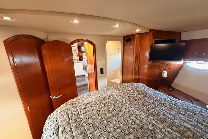 Slide: The Image of Luxurious 2005 Cruisers Yachts 405 Express Motoryacht bedroom with wood accents and TV. - 62
