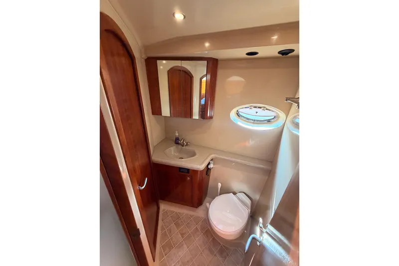 Slide: The Image of Luxurious bathroom in 2005 Cruisers Yachts 405 Express Motoryacht with wood accents and porthole. - 55
