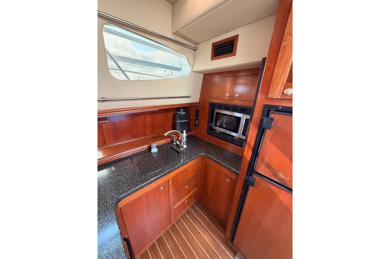 Slide: The Image of 2005 Cruisers Yachts 405 Express Motoryacht kitchen with wood cabinetry and modern appliances. - 45