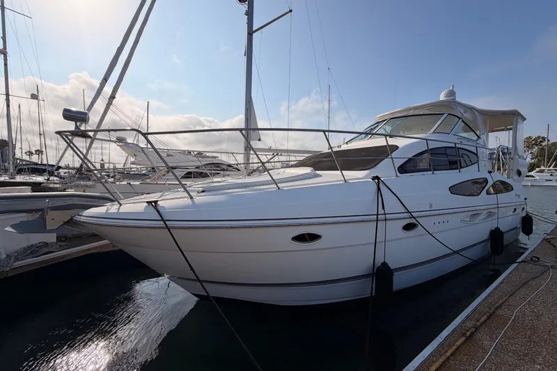 Slide: The Image of 2005 Cruisers Yachts 405 Express Motoryacht docked at marina under clear sky. - 3