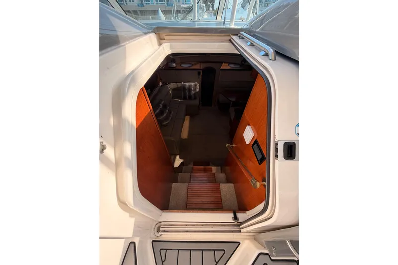 Slide: The Image of 2005 Cruisers Yachts 405 Express Motoryacht interior view with wooden stairs and cozy seating. - 39