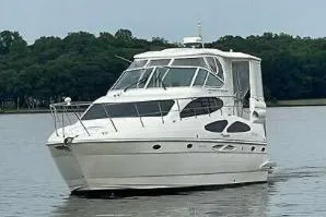 Slide: The Image of 2005 Cruisers Yachts 405 Express Motoryacht on calm water, surrounded by trees. - 95