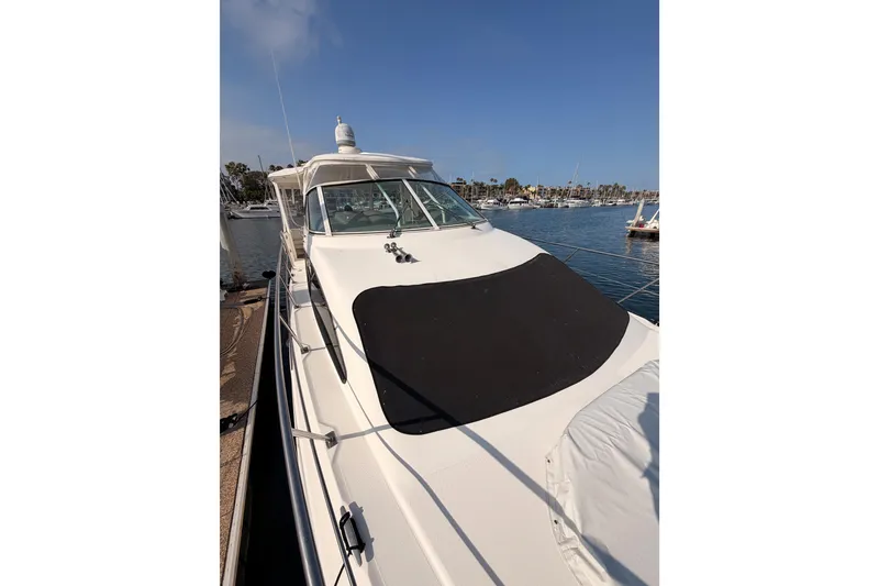 Slide: The Image of 2005 Cruisers Yachts 405 Express Motoryacht docked at marina under clear blue sky. - 22