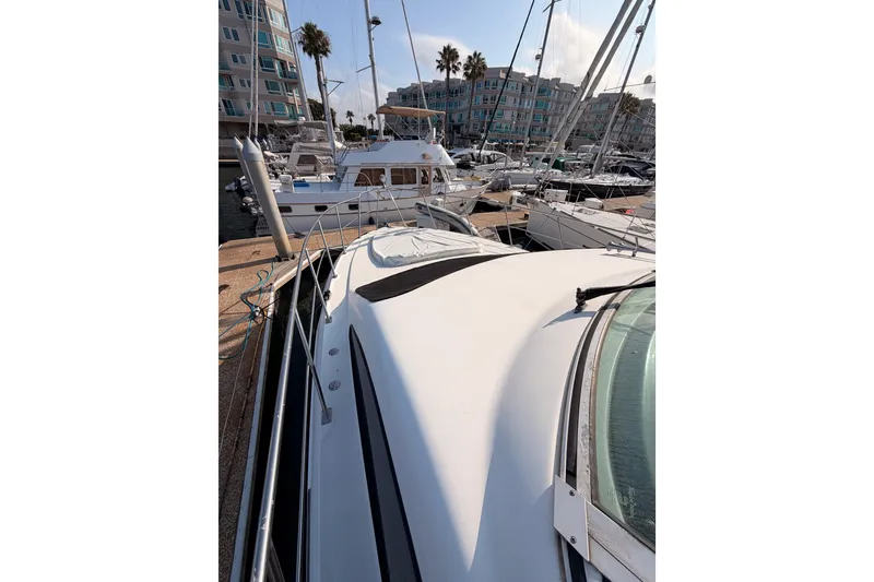 Slide: The Image of 2005 Cruisers Yachts 405 Express Motoryacht docked in a marina with other boats. - 18