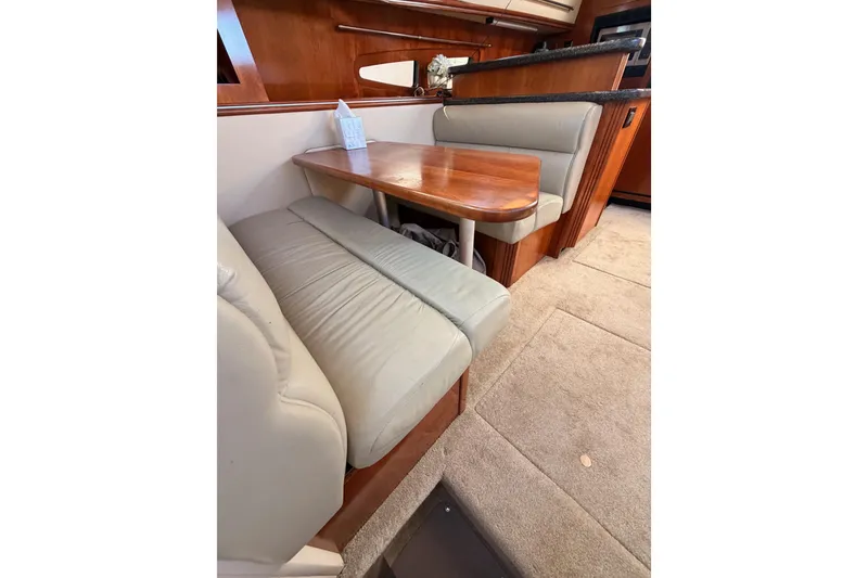 Slide: The Image of 2005 Cruisers Yachts 405 Express Motoryacht interior dining area with cushioned seating. - 69
