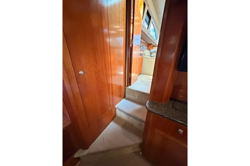 Slide: The Image of Interior view of 2005 Cruisers Yachts 405 Express Motoryacht with wooden paneling and carpeted steps. - 86