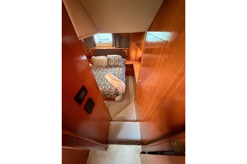Slide: The Image of 2005 Cruisers Yachts 405 Express Motoryacht cabin with cozy bed and wooden interior. - 75