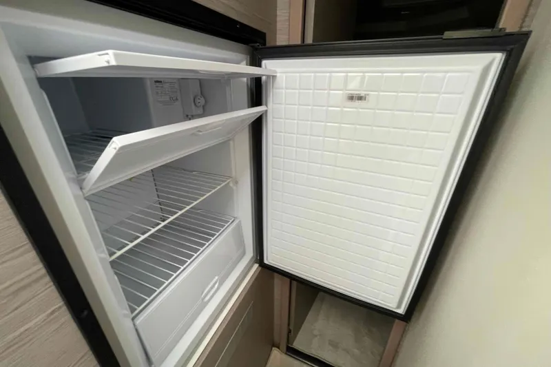 Slide: The Image of Open refrigerator inside 2022 Fountaine Pajot MY4.S yacht, showcasing spacious interior shelves. - 35
