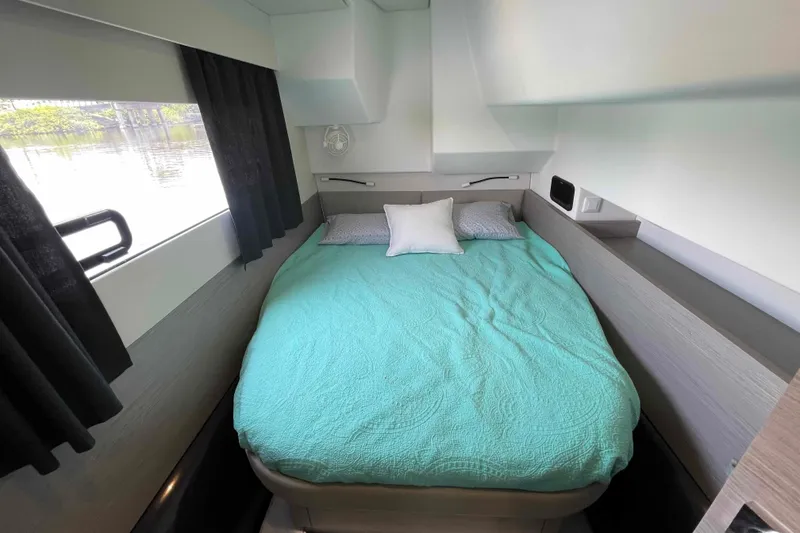Slide: The Image of Cozy cabin interior of 2022 Fountaine Pajot MY4.S with teal bedding and window view. - 33
