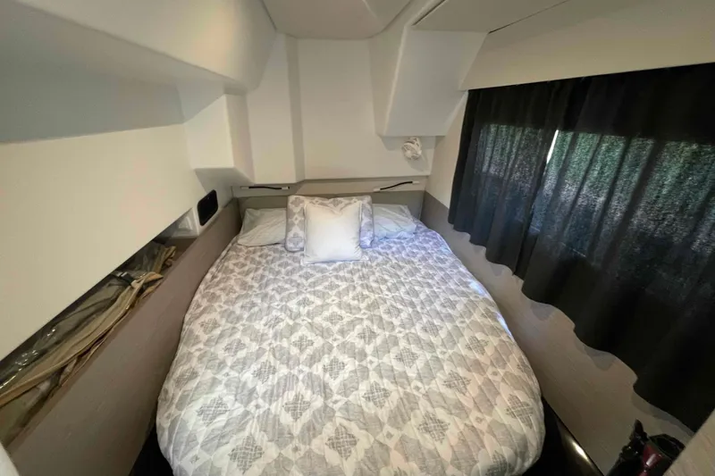 Slide: The Image of Cozy bedroom interior of 2022 Fountaine Pajot MY4.S yacht with patterned bedding and curtains. - 20
