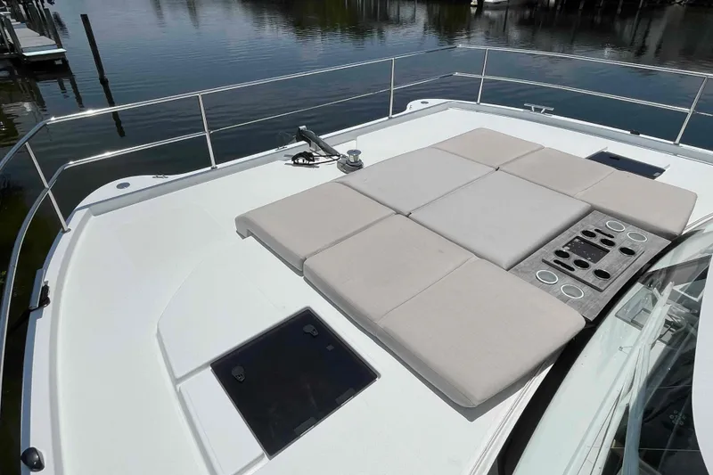 Slide: The Image of 2022 Fountaine Pajot MY4.S yacht deck with cushioned seating and cup holders. - 17