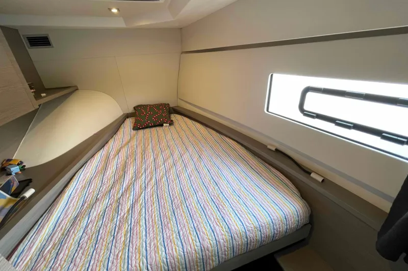 Slide: The Image of Cozy cabin interior of 2022 Fountaine Pajot MY4.S with striped bedding and window. - 38