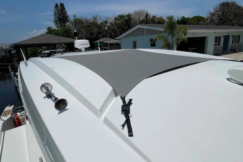Slide: The Image of 2022 Fountaine Pajot MY4.S yacht with sunshade, docked near waterfront home. - 18