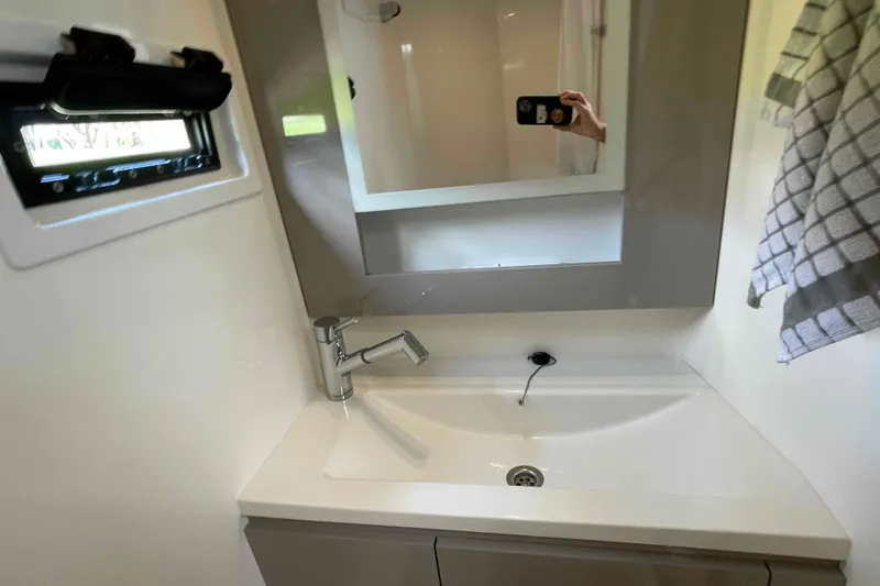 Slide: The Image of Modern bathroom sink in 2022 Fountaine Pajot MY4.S yacht, featuring sleek design and mirror. - 24
