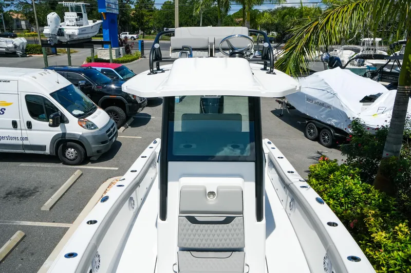 Slide: The Image of 2026 Blackfin 262 HB boat in a parking lot with surrounding vehicles and greenery. - 21