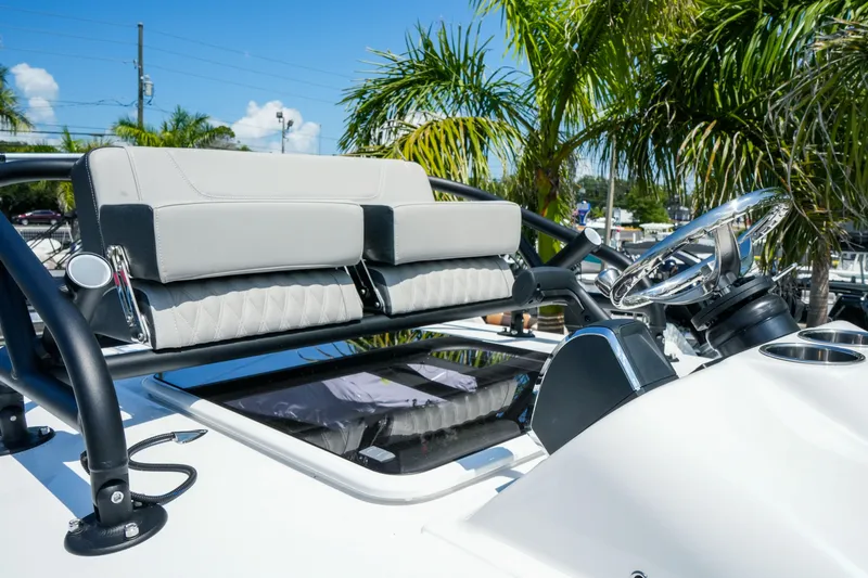 Slide: The Image of 2026 Blackfin 262 HB boat helm with sleek seating and steering, surrounded by palm trees. - 23