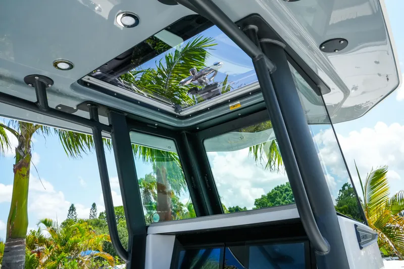 Slide: The Image of 2026 Blackfin 262 HB boat with sleek design, glass roof, and tropical background. - 15