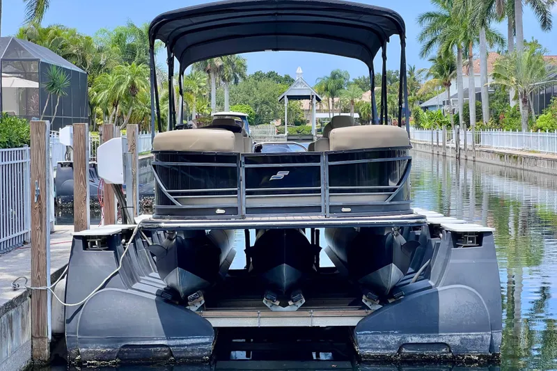 Slide: The Image of 2021 Starcraft SLS 3 pontoon boat docked in a scenic canal setting. - 2
