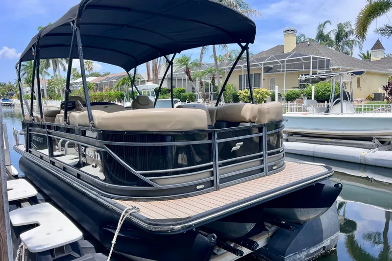 Slide: The Image of 2021 Starcraft SLS 3 pontoon boat docked in a scenic canal setting. - 3