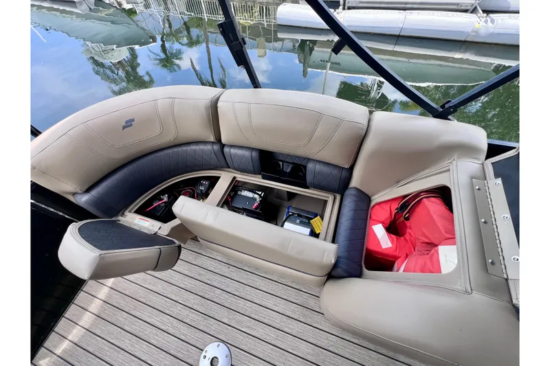Slide: The Image of 2021 Starcraft SLS 3 boat interior with storage compartments open, revealing equipment and life jackets. - 21