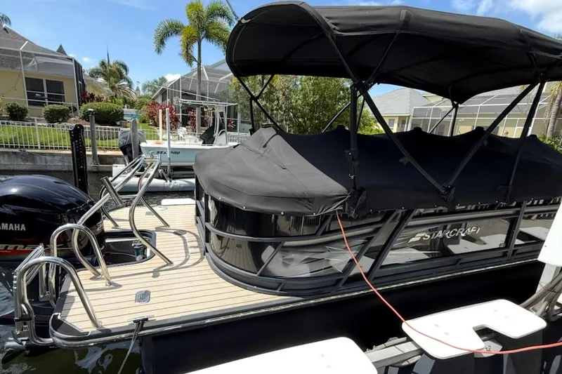 Slide: The Image of 2021 Starcraft SLS 3 pontoon boat docked with Yamaha engine, covered and ready for use. - 8