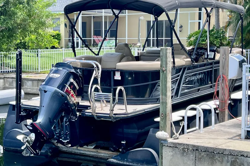 Slide: The Image of 2021 Starcraft SLS 3 pontoon boat docked with Yamaha outboard motor. - 10