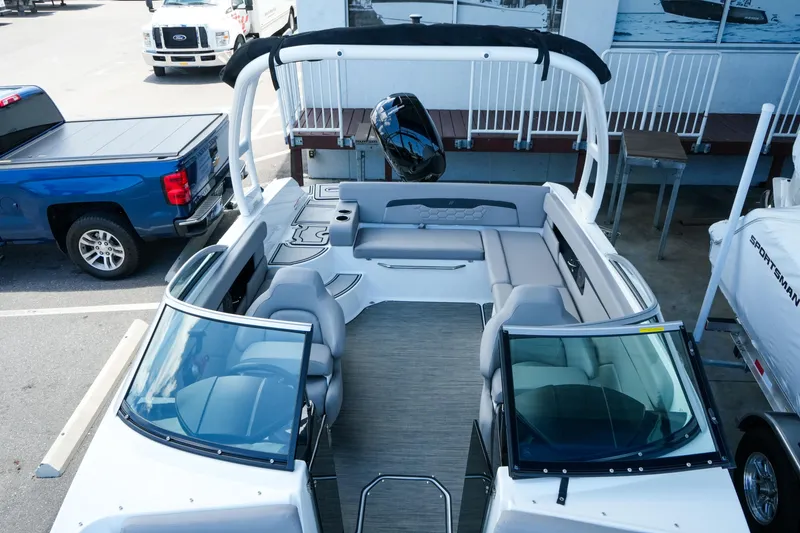 Slide: The Image of 2027 Four Winns HD2 OB boat with spacious seating and modern design in a parking area. - 23