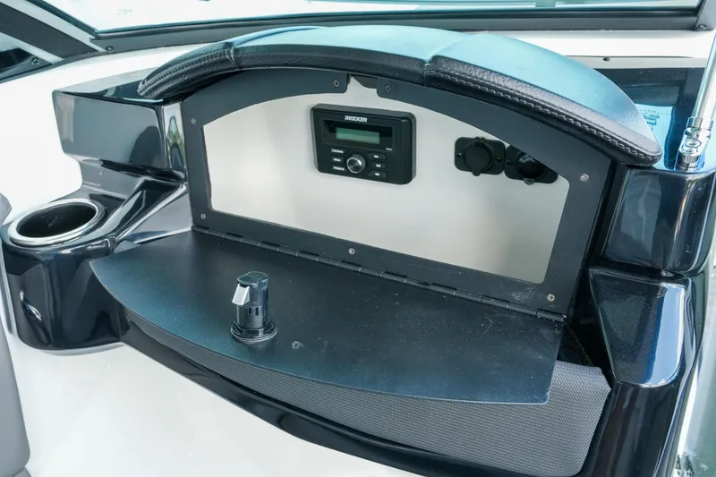 Slide: The Image of 2027 Four Winns HD2 OB boat dashboard with stereo system and cup holder. - 18