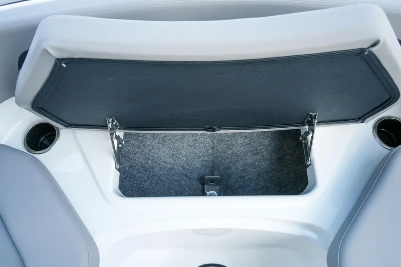 Slide: The Image of Open storage compartment in 2027 Four Winns HD2 OB boat, featuring sleek design and cup holders. - 26