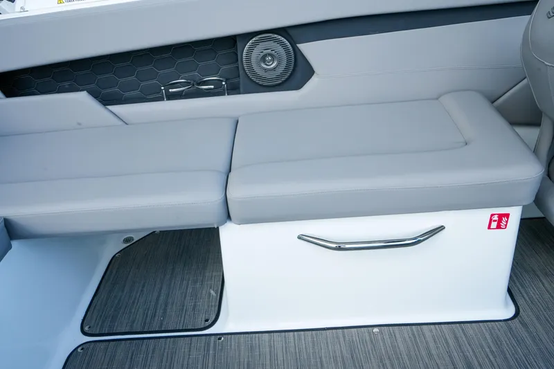Slide: The Image of 2027 Four Winns HD2 OB boat interior with gray cushioned seating and storage compartment. - 10