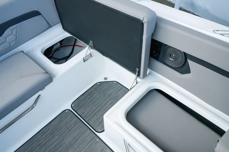 Slide: The Image of 2027 Four Winns HD2 OB boat interior with open storage compartments and speaker. - 31