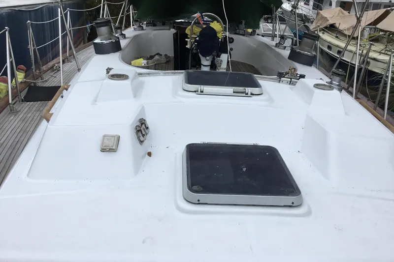 Slide: The Image of 1987 Tayana 52 yacht deck with hatches and winches, docked at a marina. - 5