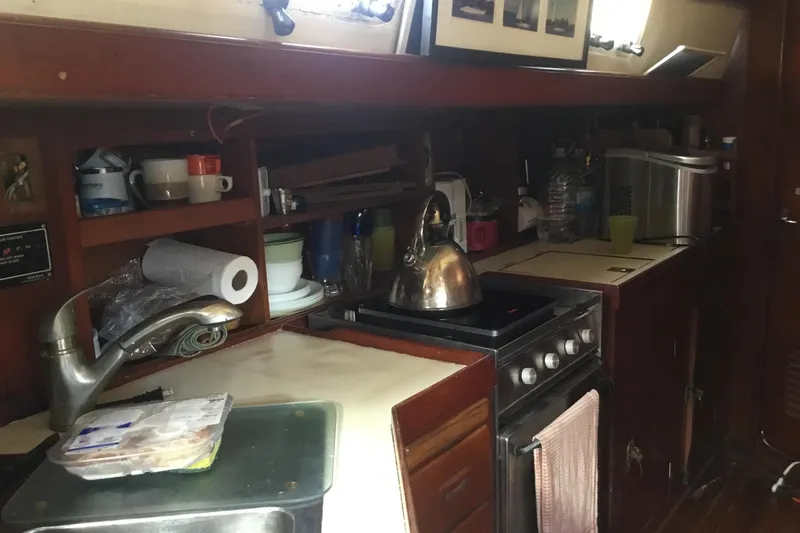 Slide: The Image of Galley kitchen in 1987 Tayana 52 sailboat with stove, sink, and kettle. - 18
