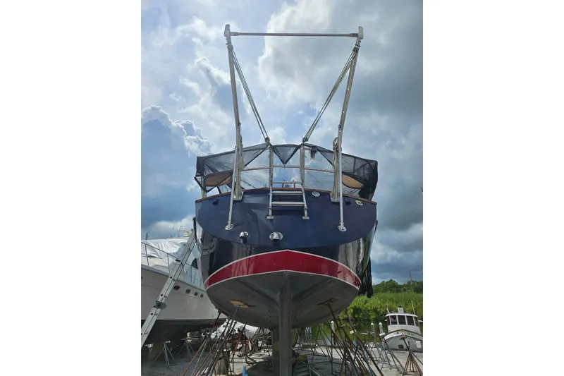 Slide: The Image of 1987 Tayana 52 sailboat on dry dock under cloudy sky. - 32