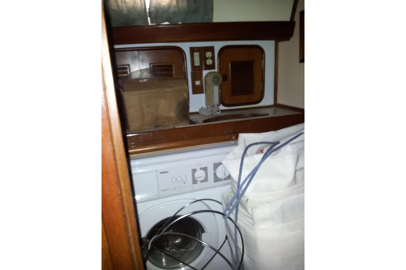 Slide: The Image of Laundry area inside a 1987 Tayana 52 yacht, featuring a Haier washing machine. - 15