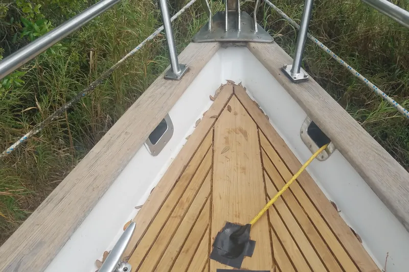Slide: The Image of Bow of 1987 Tayana 52 sailboat with wooden deck and metal railings. - 3