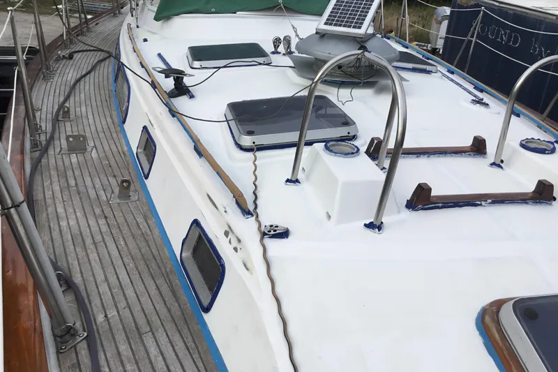 Slide: The Image of 1987 Tayana 52 sailboat deck with solar panel and hatches, showcasing classic design. - 6