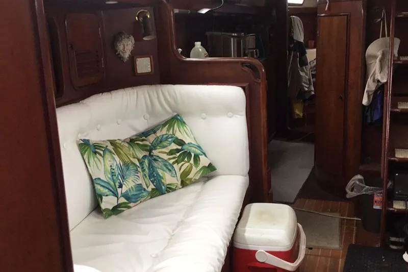 Slide: The Image of Cozy interior of 1987 Tayana 52 yacht with white sofa and tropical pillow. - 27