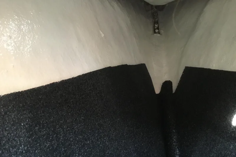 Slide: The Image of Interior view of a 1987 Tayana 52 yacht hull with black insulation. - 32