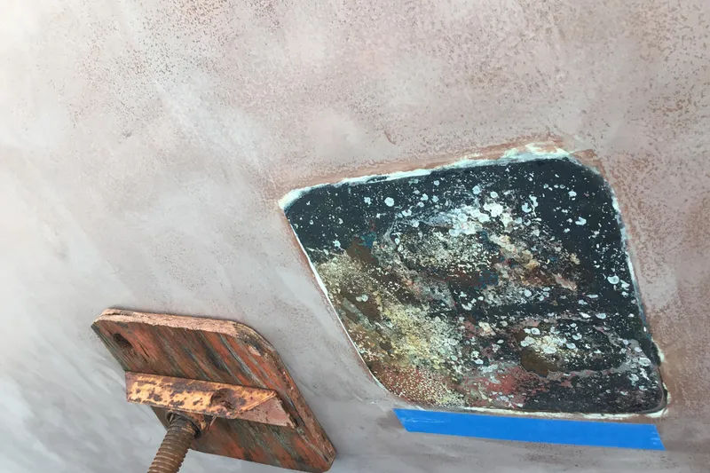 Slide: The Image of Rusty metal clamp on weathered Tayana 52 boat hull, 1987 model. - 17